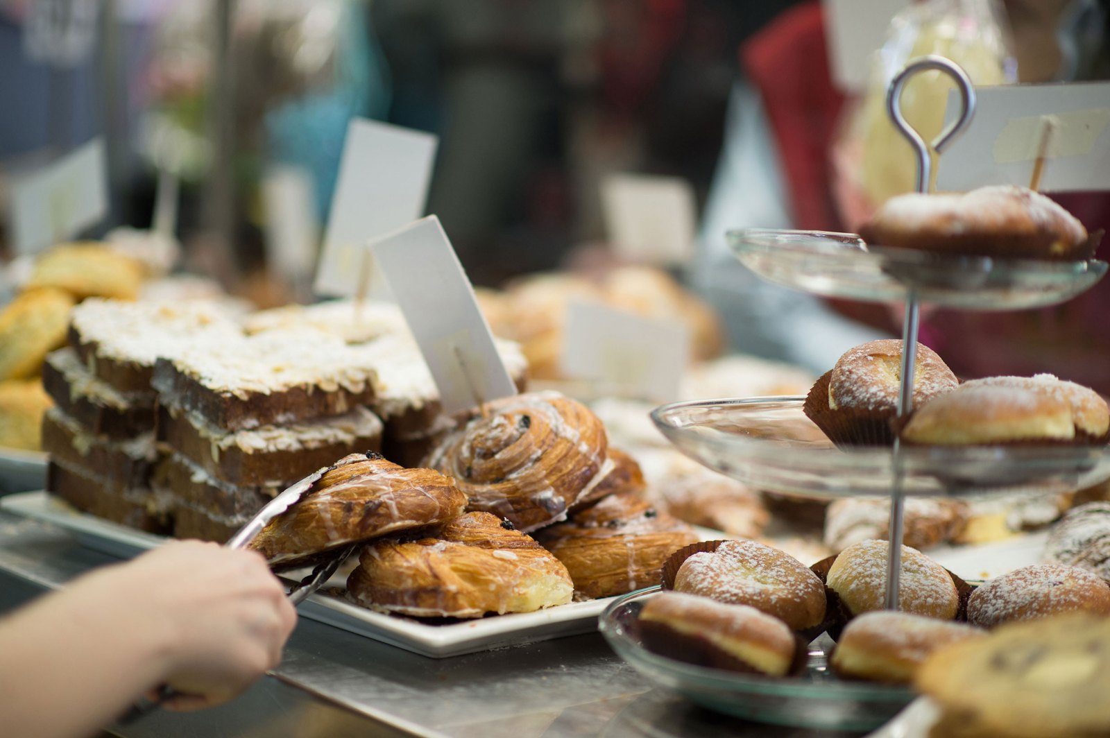 Pastry counter at Art Is In Bakery stacked with danishes, croissants and almond toast