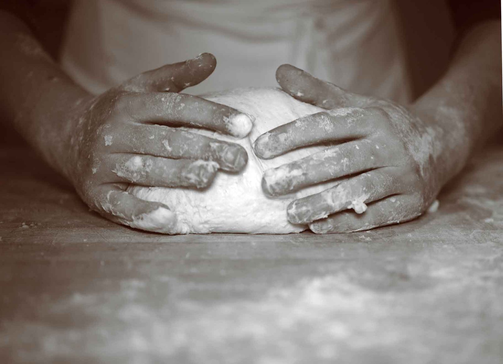 Baker's hands shaping sourdough at the bench